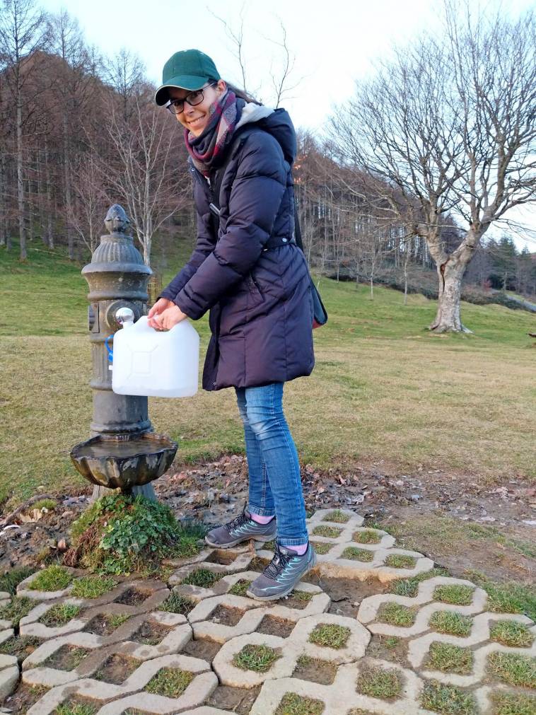Lisa holt gerade Wasser aus einem Trinkwasserbrunnen in Nordspanien / 10 Liter Trinkwasser-Kanister zum flexiblen Einsatz